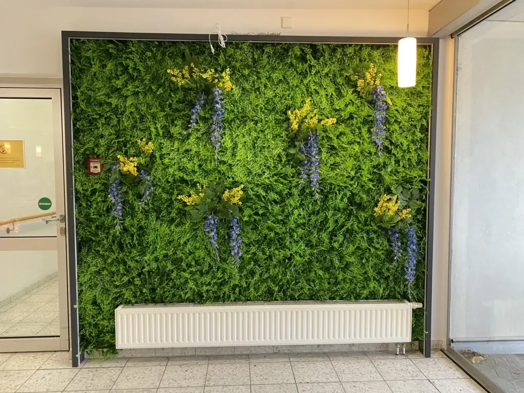 Künstliche Pflanzenwand mit verschiedenen Blattformen im Innenraum