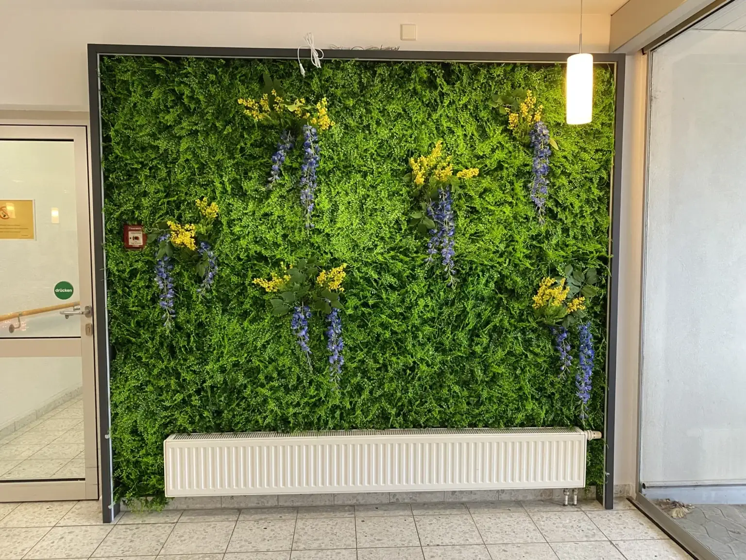 Künstliche Pflanzenwand mit verschiedenen Blattformen im Innenraum